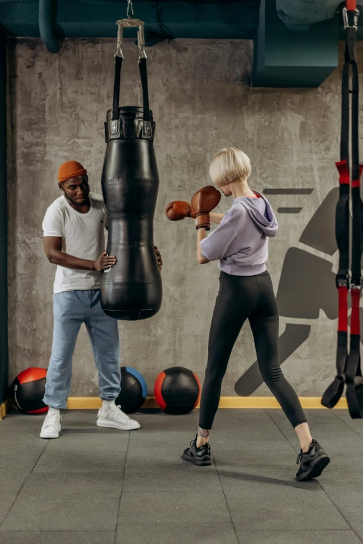 a woman hitting a punching bag in a gym, poster art, pexels contest winner, man and woman, kano), hypersphere, performance