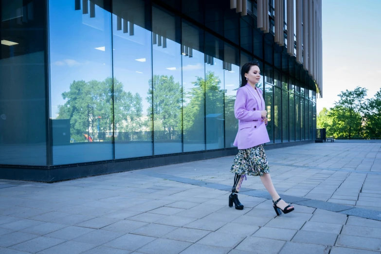 a woman walking down a sidewalk in front of a building, inspired by Fei Danxu, unsplash, prostheses, wearing jacket and skirt, bright colour, bionic implants