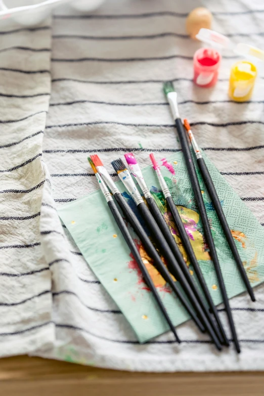 a bunch of paint brushes sitting on top of a towel, an acrylic painting, unsplash, colour print, multi - coloured, flatlay, starry