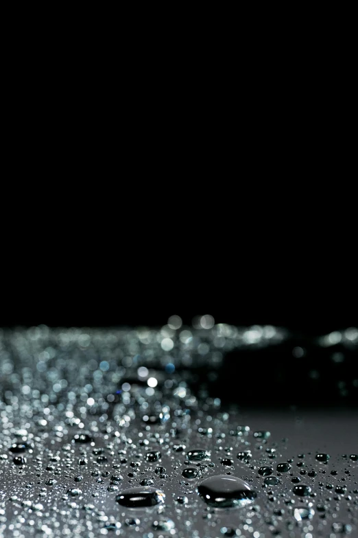 a close up of water droplets on a surface, an album cover, by artist, unsplash, kinetic pointillism, glowing with silver light, black backdrop, glowing crystals on the ground, gradient black to silver