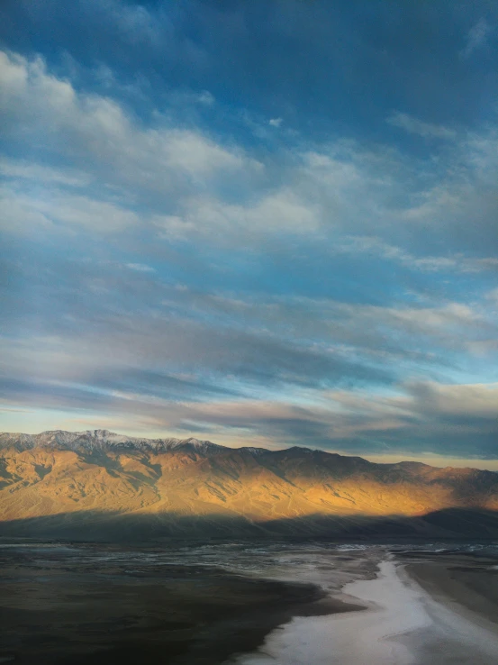 a large body of water with mountains in the background, a detailed matte painting, by Morris Kestelman, unsplash contest winner, death valley, laura letinsky and steve mccurry, dramatic morning light, wide high angle view