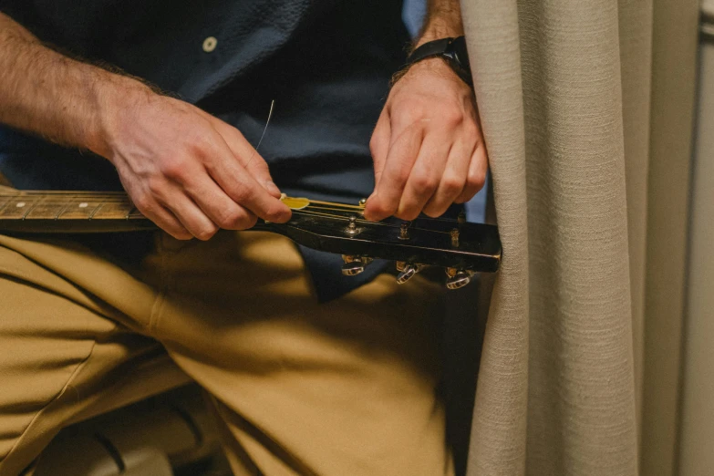 a close up of a person holding a guitar, maintenance, tailored clothing, rectangle, instrument