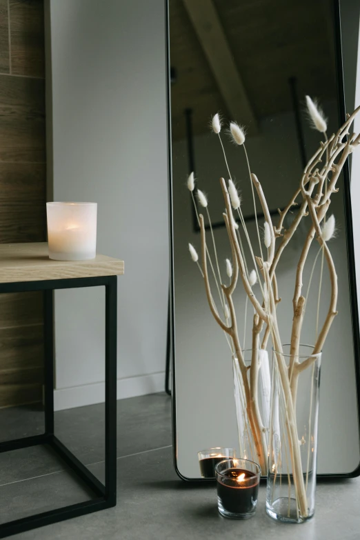 a mirror sitting on top of a table next to a vase, light and space, natural candle lighting, zoomed in, clean image, walking down