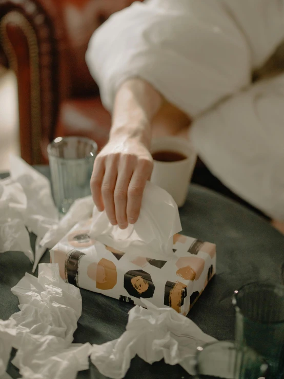 a person sitting at a table with a box of tissues, a marble sculpture, by Emma Andijewska, pexels contest winner, thumbnail, cysts, seasonal, nursing