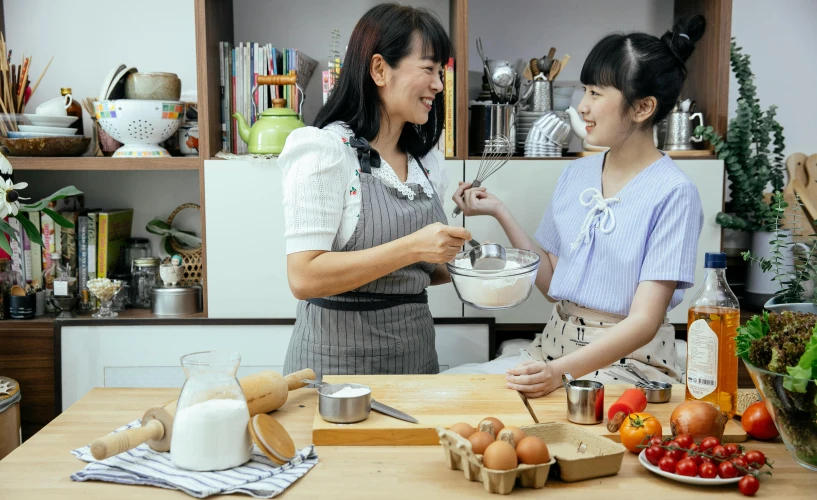 a couple of women standing next to each other in a kitchen, inspired by Yukimasa Ida, pexels contest winner, dau-al-set, for displaying recipes, in style of pan ren wei, kitchen counter, lalisa manobal