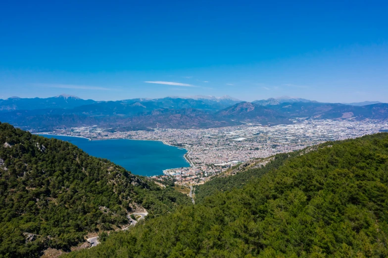 a large body of water sitting on top of a lush green hillside, pexels contest winner, hurufiyya, mountains and a huge old city, mount olympus, views to the ocean, birdseye view