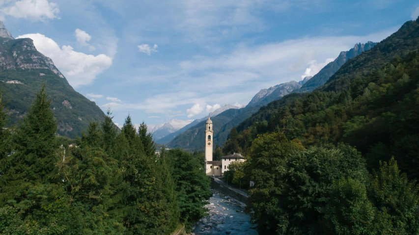 a river running through a lush green valley, an album cover, by Otto Meyer-Amden, pexels contest winner, churches, vouge italy, spire, a cozy