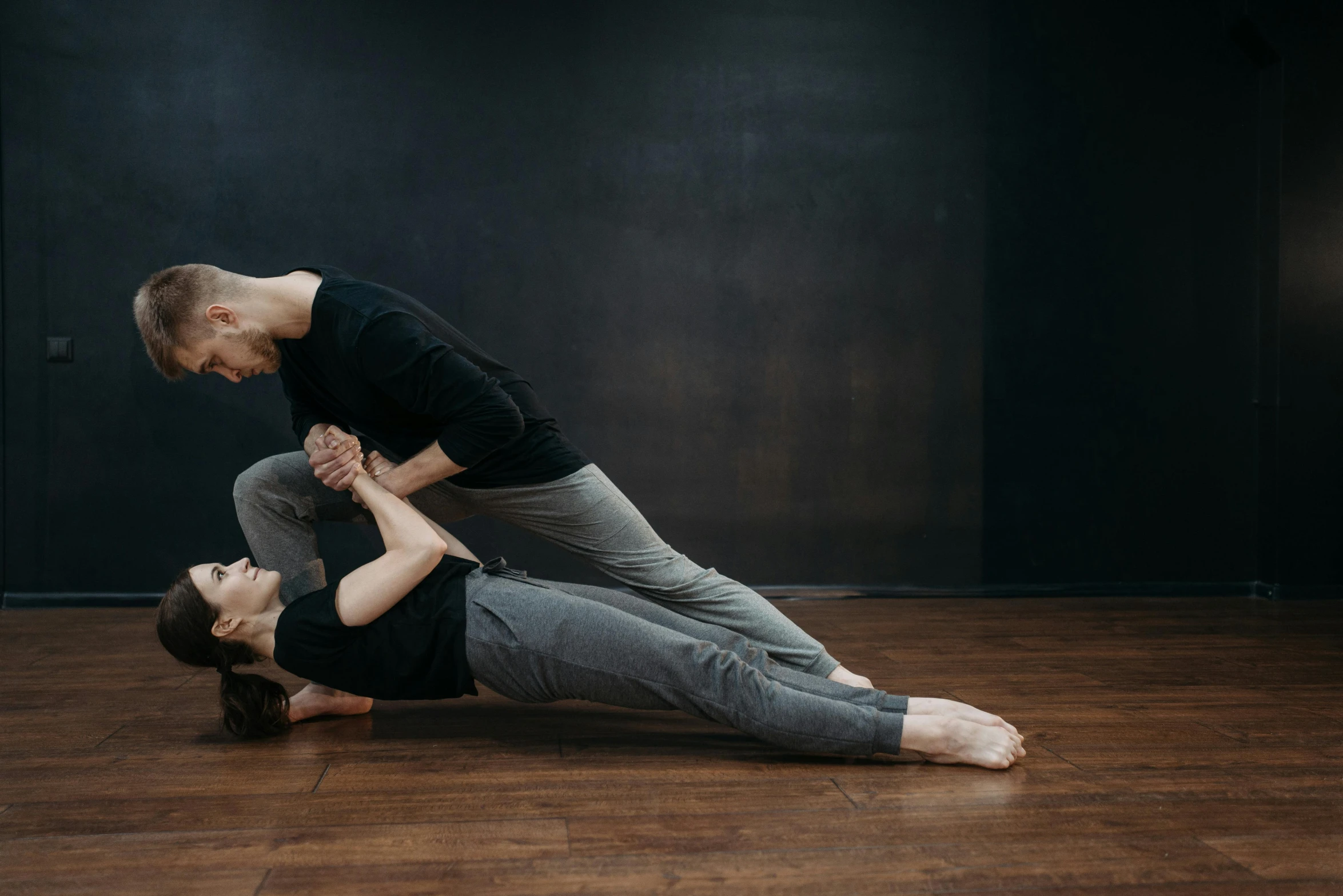 a man and a woman doing yoga together, by Emma Andijewska, arabesque, laying down with wrists together, dancing with each other, ouchh and and innate studio, standing sideways