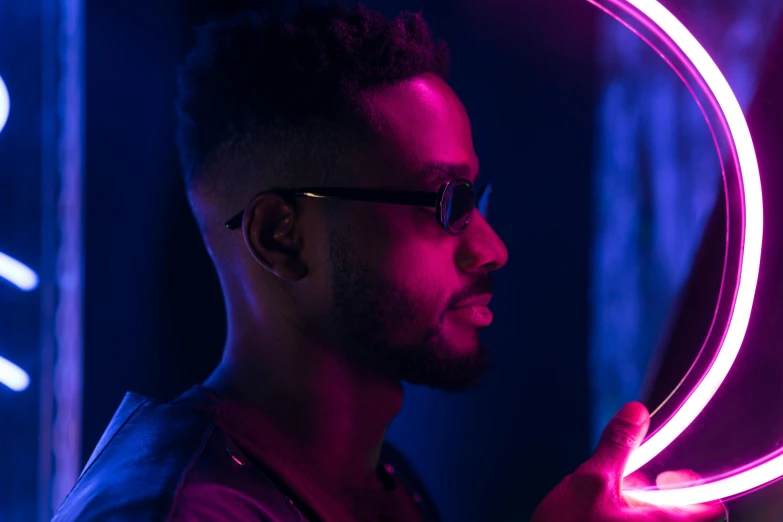 a man standing in front of a neon sign, pexels contest winner, afrofuturism, looking into a mirror, handsome man, melanchonic rose soft light, ( ( dark skin ) )