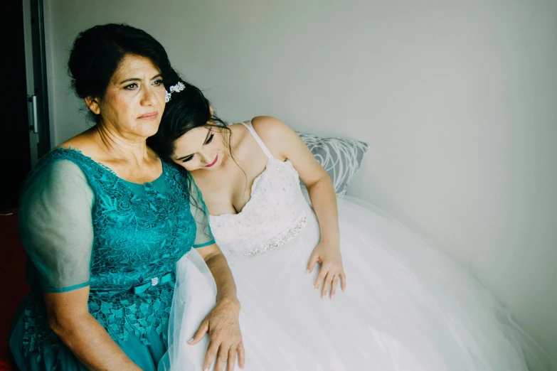 a woman standing next to a woman in a wedding dress, by Elsa Bleda, pexels contest winner, hurufiyya, teal color graded, resting, family friendly, straya