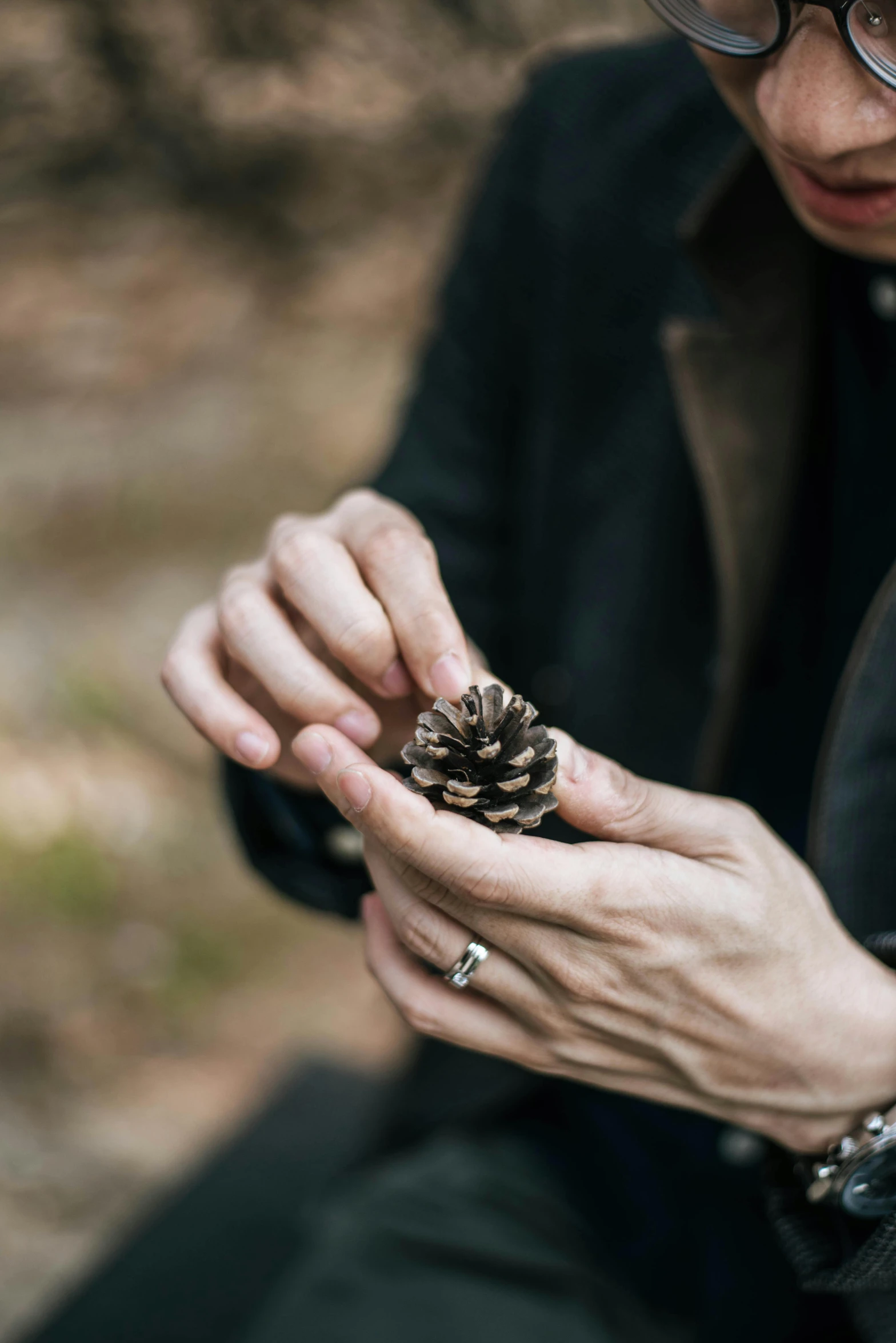 a close up of a person holding a pine cone, inspired by Andy Goldsworthy, naturalism, connection rituals, elder ring, gentleman, creating a soft