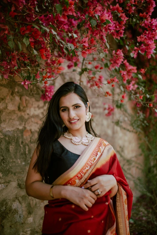 a woman in a red sari posing for the camera, pexels contest winner, flowers in her dark hair, square, ✨🕌🌙, wearing an elegant outfit