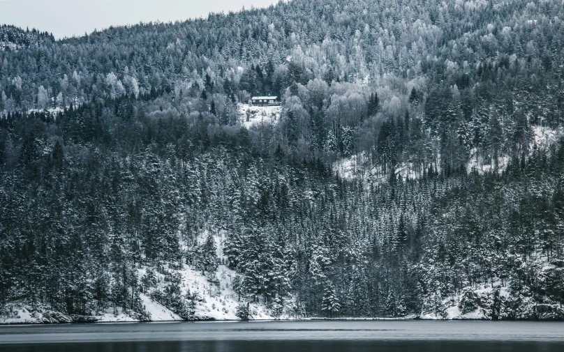 a mountain covered in snow next to a body of water, inspired by Pierre Pellegrini, pexels contest winner, renaissance, house in forest, grey, house on a hill, quebec
