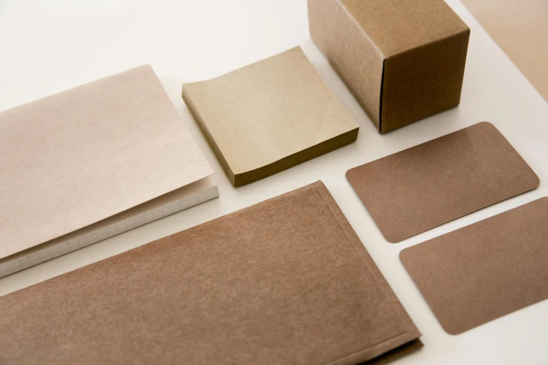 several pieces of cardboard sitting on top of a table, unsplash, private press, square shapes, taupe, plain background, labels