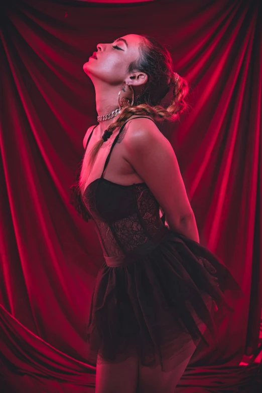 a woman standing in front of a red curtain, passionate pose, wearing a dark dress, profile image, corsets