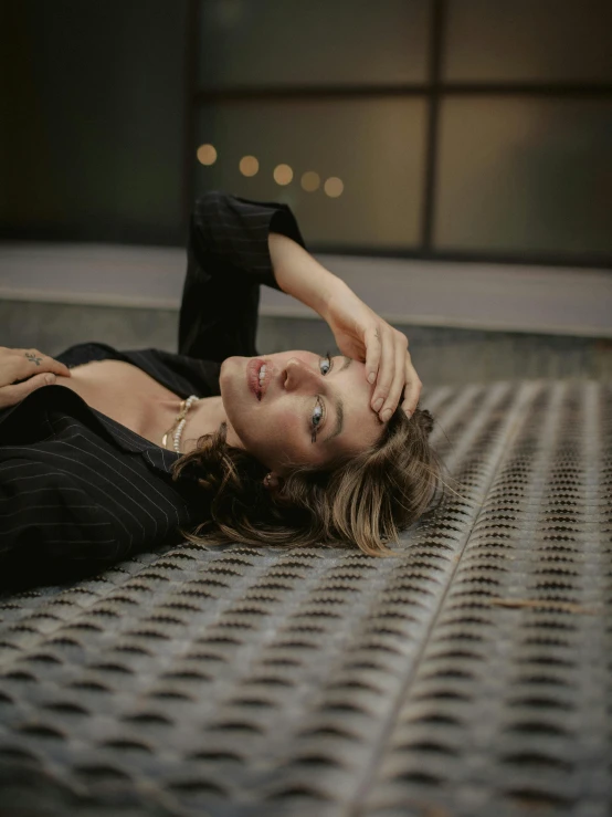 a beautiful woman laying on top of a metal floor, inspired by Elsa Bleda, trending on pexels, happening, looking off to the side, androgynous person, sofia coppola, head tilted down