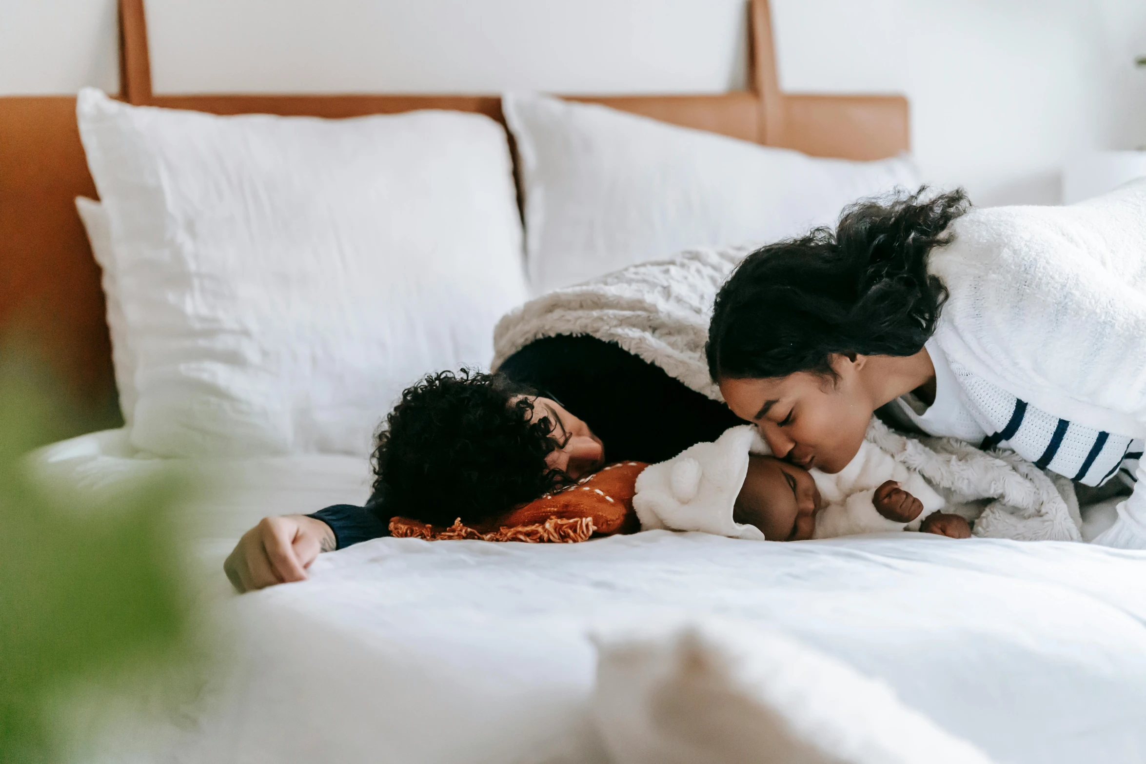 a woman laying on top of a bed next to a baby, pexels contest winner, happening, husband wife and son, profile image, thumbnail, hugging