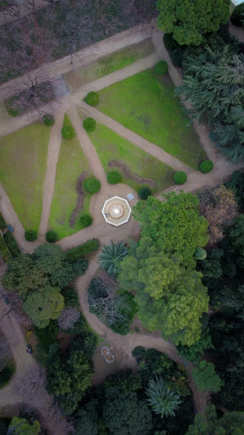 an aerial view of a park with a fountain, inspired by Alexander Nasmyth, pexels, land art, in avila pinewood, sundial, woodland setting, dome