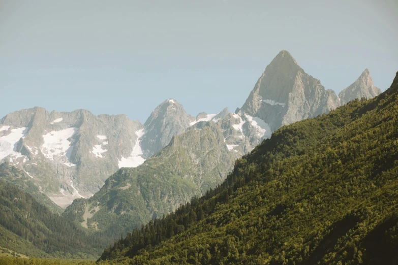 a herd of cattle standing on top of a lush green hillside, an album cover, by Daniël Mijtens, unsplash contest winner, chamonix, tall stone spires, seen from a distance, 4 k hd wallpapear