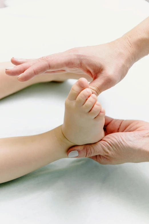 a close up of a person holding a baby's hand, dribble, tendons, professional, foot wraps, thumbnail