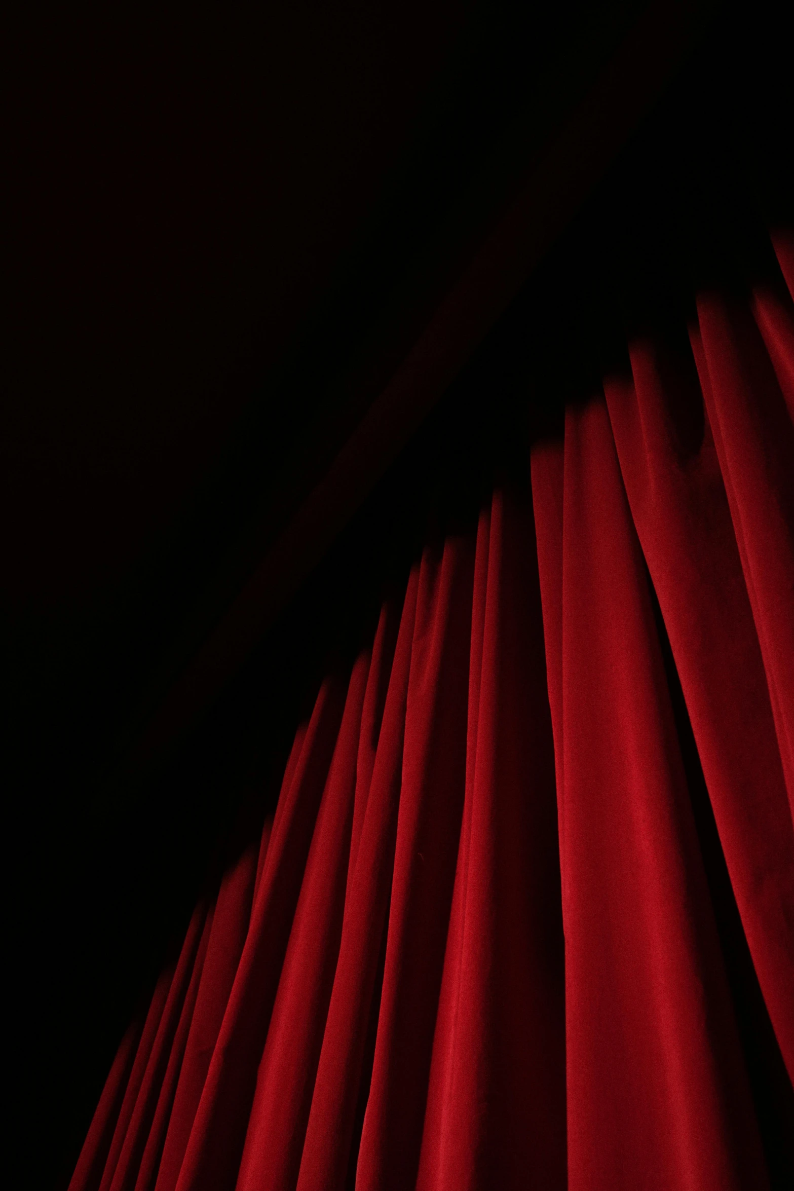 a red curtain in a dark room