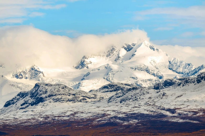 a large mountain covered in snow on a cloudy day, by Roar Kjernstad, pexels contest winner, hurufiyya, icy mountains in the background, panoramic, mountains of ice cream, profile picture 1024px