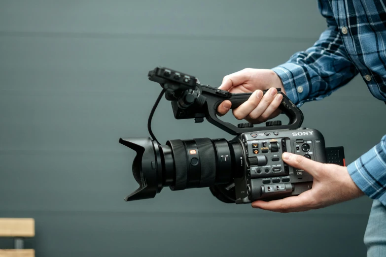 a close up of a person holding a camera, sony fx 6, high quality product image”, b - roll, extra high resolution