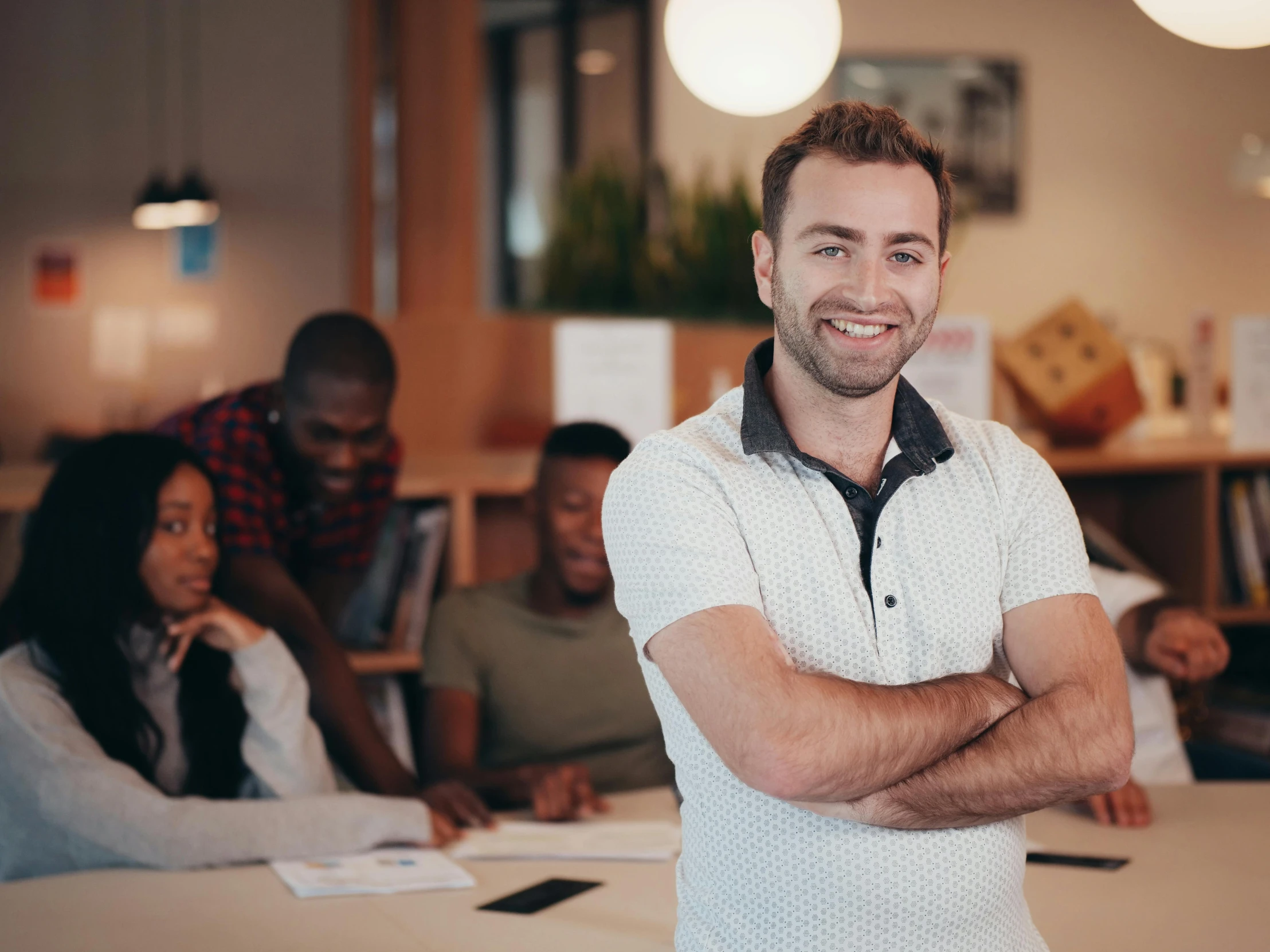 a man standing in front of a group of people, on a desk, 9 9 designs, photogenic, developers