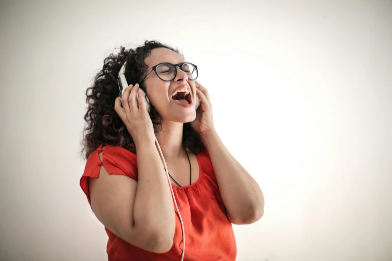 a woman with glasses talking on a cell phone, an album cover, pexels, singing, red headphones, euphoric, thumbnail