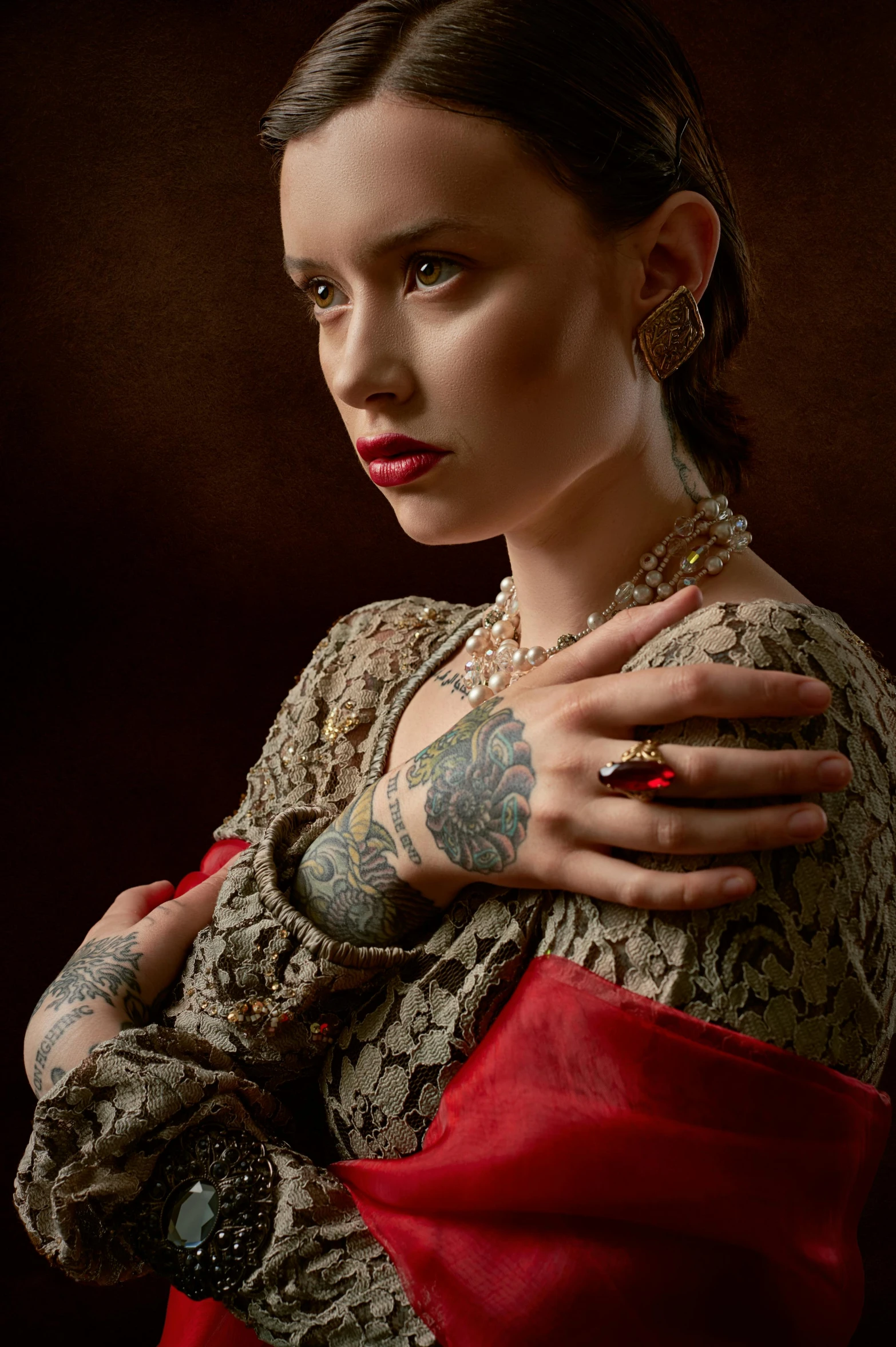 a woman with a tattoo on her arm, inspired by Agnolo Bronzino, shutterstock contest winner, renaissance, red jewelry, model shoot, in victorian aristocrat, photo from a promo shoot