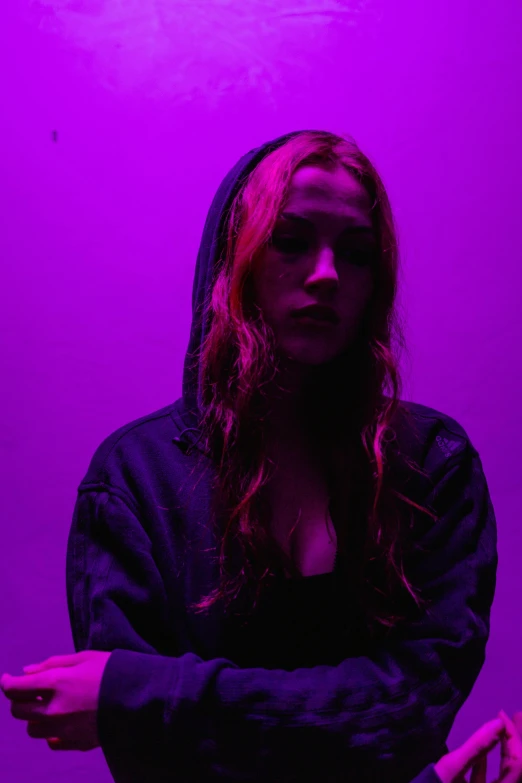 a woman standing in front of a purple light, in a black hoodie, a redheaded young woman, alexa grace, epk