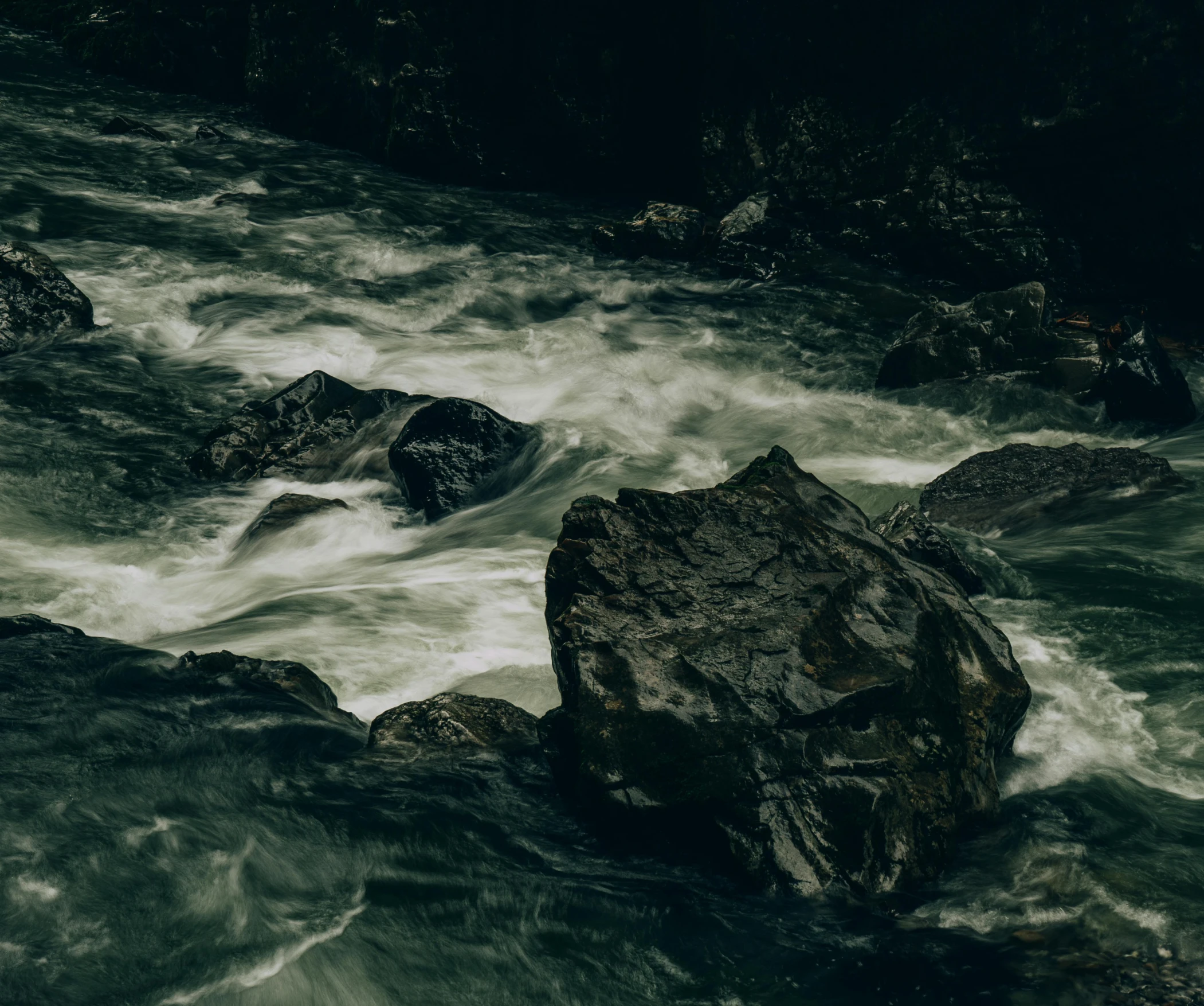 a group of rocks sitting on top of a river, an album cover, pexels contest winner, hurufiyya, turbulent water, ominous depths, unsplash 4k, river rapids