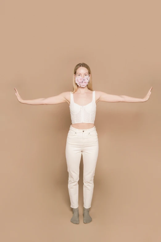 a woman that is standing up in the air, white mask, wearing crop top, on a pale background, avoid symmetry