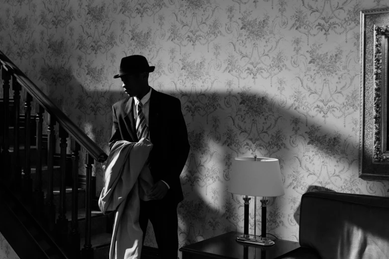 a black and white photo of a man in a suit and tie, inspired by Gordon Parks, harlem renaissance, in style of edward hopper, mystery and detective themed, filmstill, an intruder