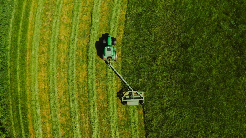a tractor that is sitting in the grass, by Attila Meszlenyi, pexels contest winner, realism, aerial footage, mowing of the hay, profile image, heavy green