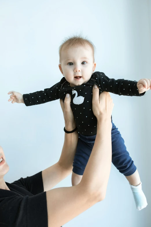 a woman holding a baby up in the air, curated collections, ready to model, rectangle, high-resolution