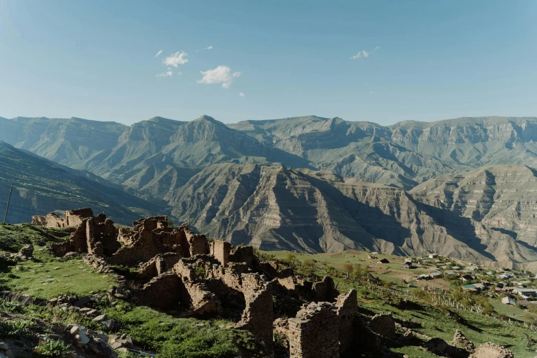 a man standing on top of a lush green hillside, by Muggur, les nabis, crumbling ancient skyscrapers, background image, mountain ranges, conde nast traveler photo