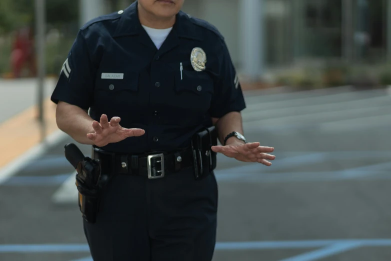 a female police officer standing in a parking lot, unsplash, photorealism, shrugging, los angeles ca, b - roll, hands