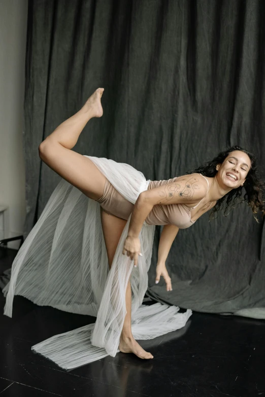 a woman in a white dress posing for a picture, an album cover, inspired by Elizabeth Polunin, pexels contest winner, brunette fairy woman stretching, gif, grey, thicc