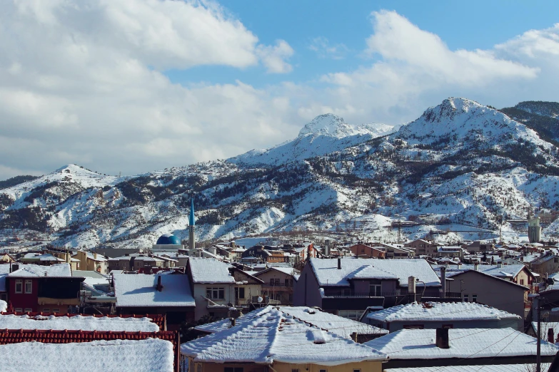 a view of a town with a mountain in the background, by Muggur, pexels contest winner, hurufiyya, covered in snow, panels, 2000s photo, ayanamikodon and irakli nadar