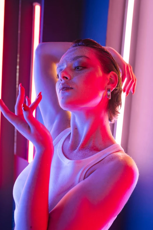 a woman standing in front of a neon light, inspired by Elsa Bleda, pexels contest winner, bauhaus, with pale skin, milla jovovich, low saturated red and blue light, bathing in light