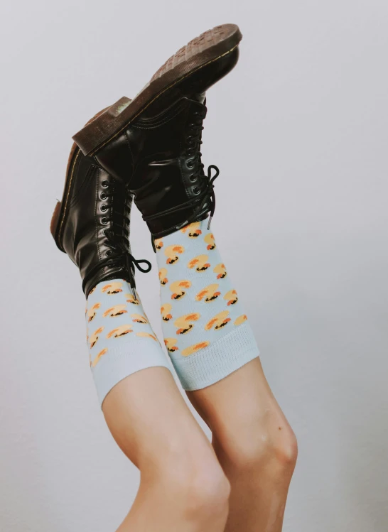 a person wearing a pair of socks with donuts on them, by Julia Pishtar, blue!! with orange details, hamburgers, vintage look, wearing a camisole and boots