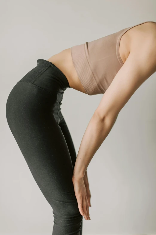 a woman doing a yoga pose on a yoga mat, by Carey Morris, tights skin, zoomed in, wearing pants, detailed product image