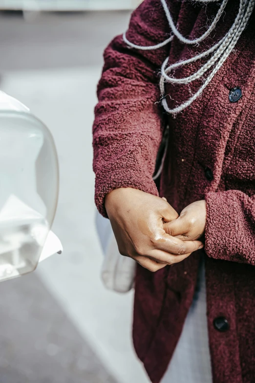 a woman holding her hands in front of a toilet, by Nina Hamnett, trending on unsplash, plasticien, diaper disposal robot, maroon, plastic and fabric, she is wearing a wet coat