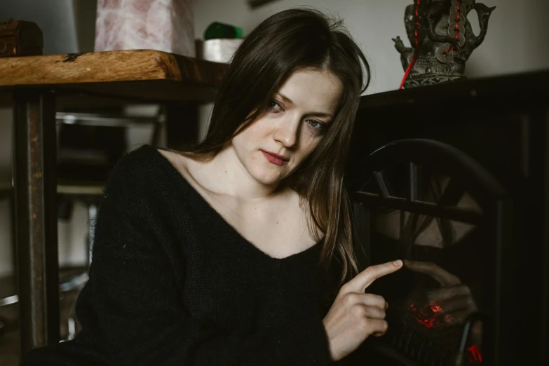 a woman sitting at a table with a plate of food in front of her, inspired by Louisa Matthíasdóttir, pexels contest winner, renaissance, wearing a black sweater, thoughtful pose, holding a burning wood piece, profile image