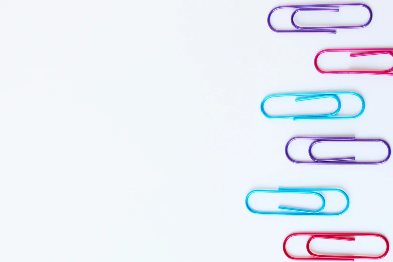 a group of paper clips sitting on top of a white surface, pexels, minimalism, magenta and crimson and cyan, computer wallpaper, colorful medical equipment, purple and blue colored