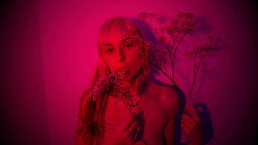 a woman holding a bunch of flowers in front of her face, an album cover, inspired by Elsa Bleda, pexels contest winner, portrait of kim petras, soft red lights, grimes - book 1 album cover, body portrait