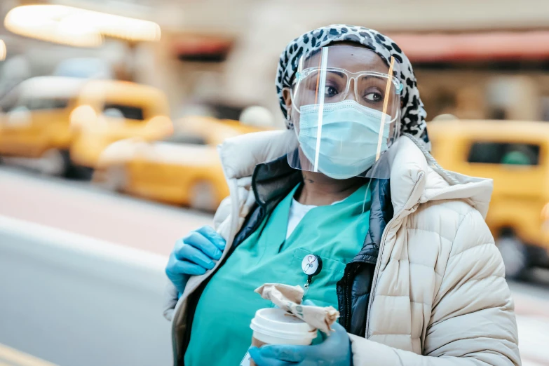 a woman wearing a face mask while holding a cup of coffee, trending on pexels, hurufiyya, nurse costume, humans of new york, essence, dressed as a scavenger