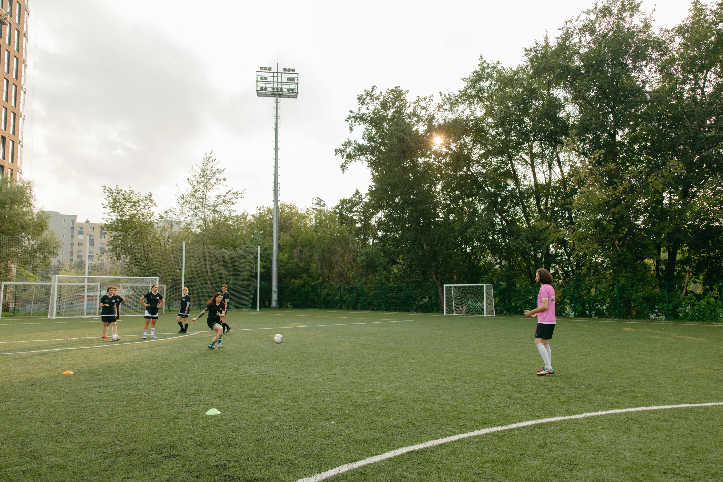 a group of people on a field playing soccer, danube school, lush surroundings, helmond, evenly lit, where a large