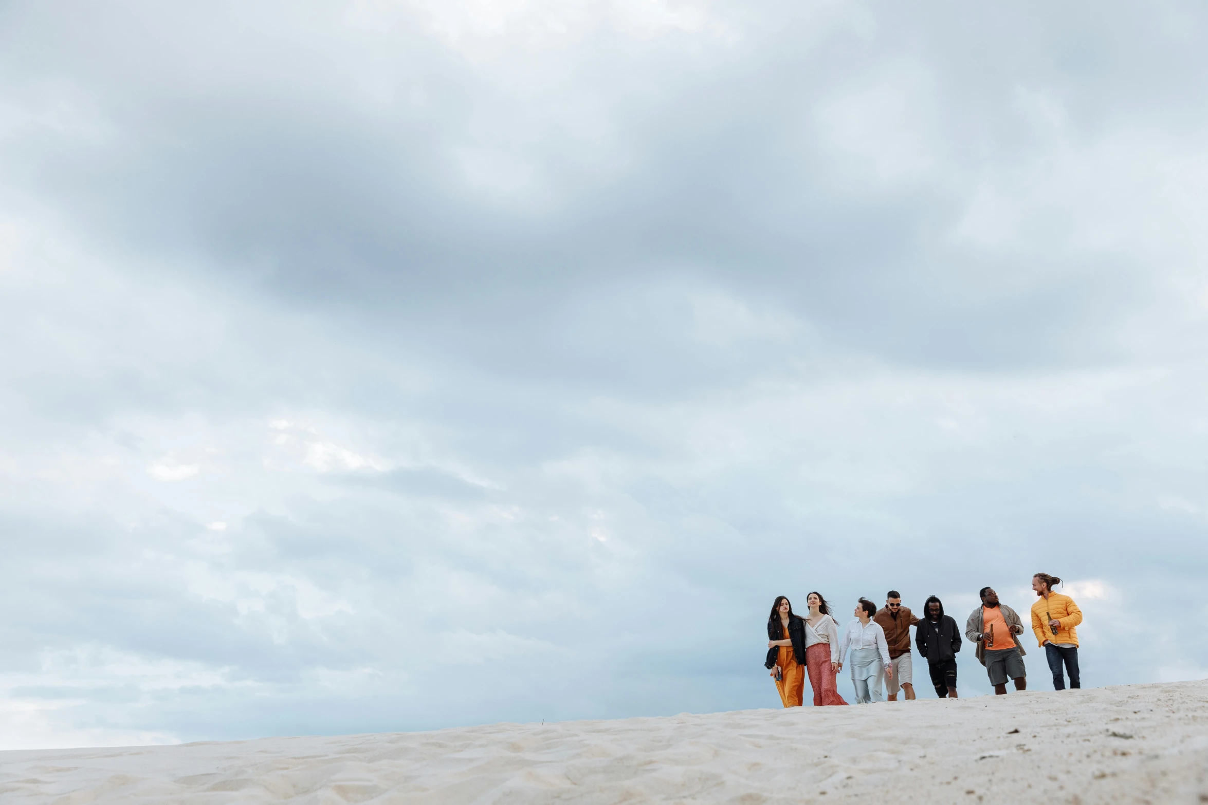 a group of people standing on top of a sandy beach, by Jessie Algie, unsplash, happening, white sand, songlines, runway photo, profile image